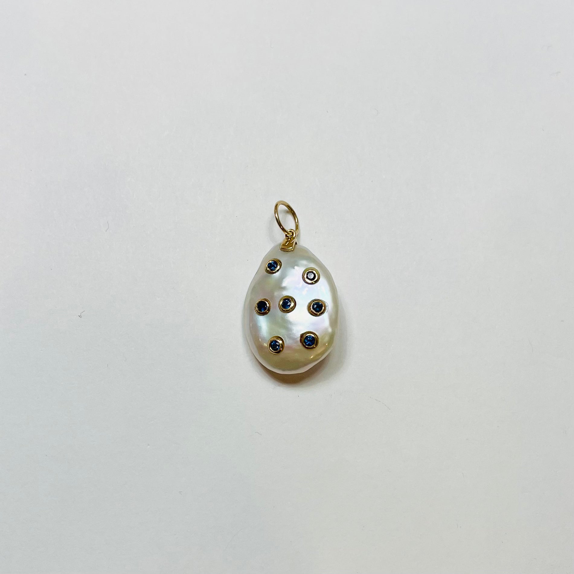 baroque pearl pendant with bezel set blue sapphires