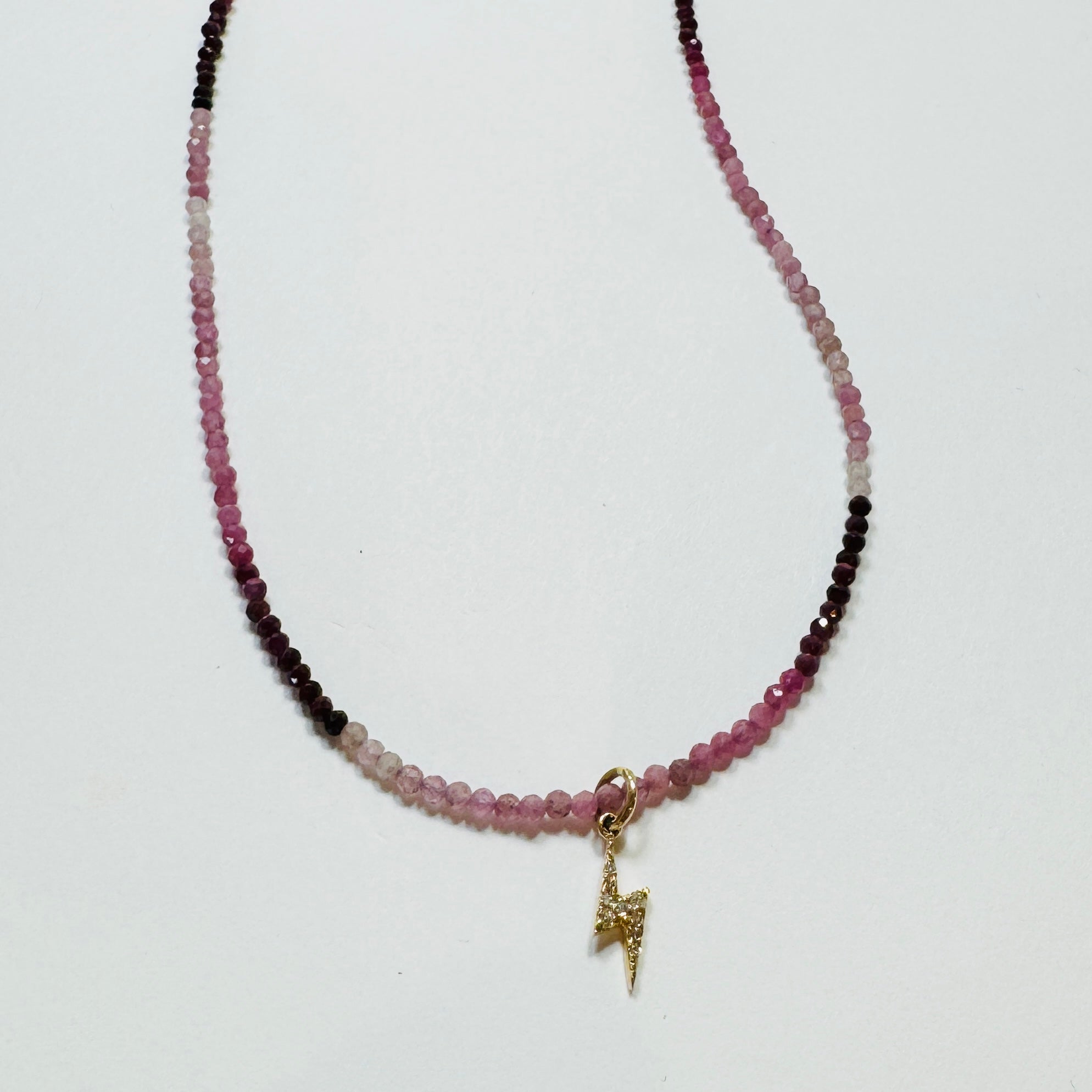 delicate shaded ruby necklace with lightning bolt charm