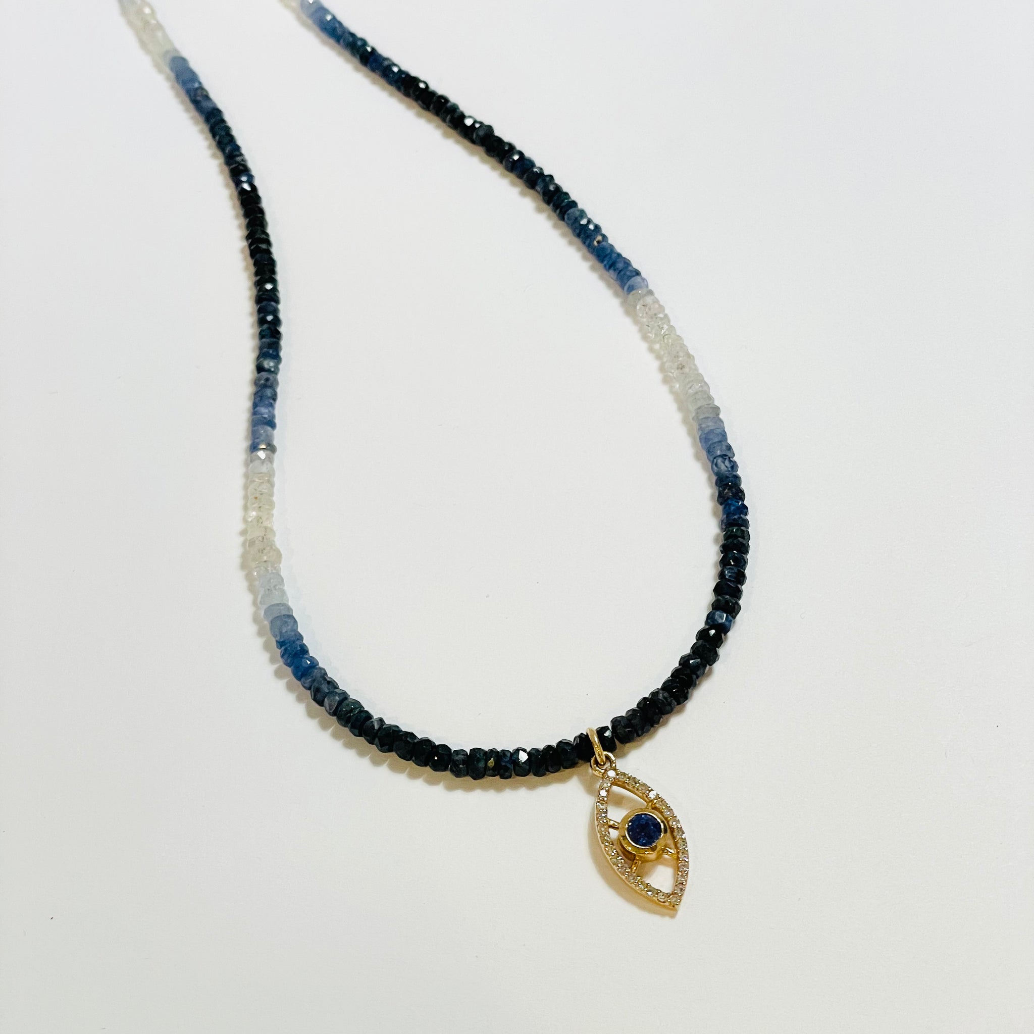 shaded blue sapphire necklace with diamond evil eye charm